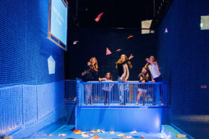 Custom stage at Scienceworks with people above flying paper planes.